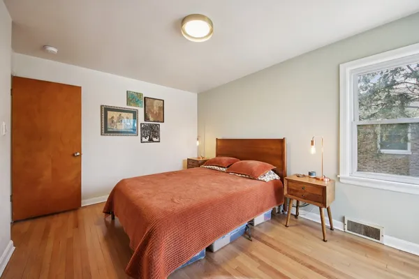 a bedroom with a bed and wooden floor