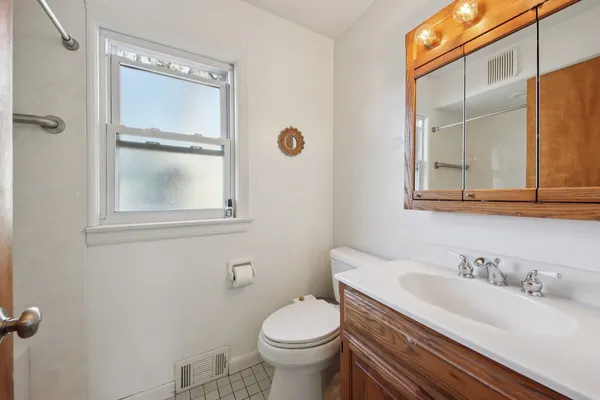 a bathroom with a granite countertop toilet sink and mirror