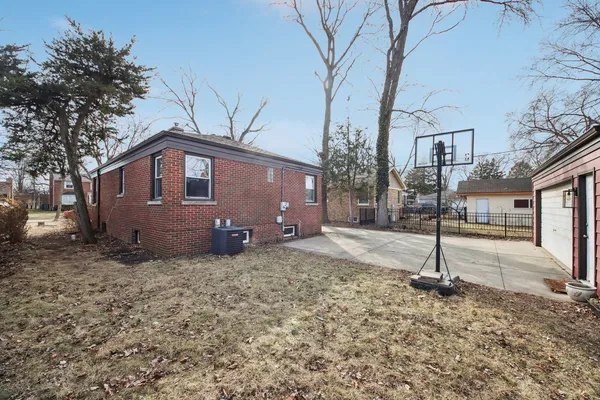 a view of a house with a yard and large tree