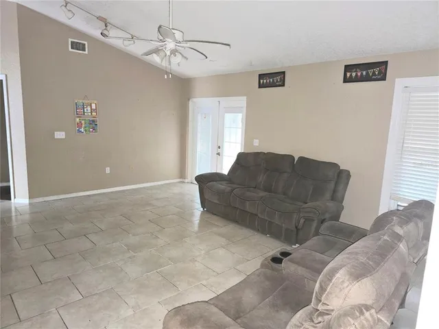 a living room with furniture and a ceiling fan