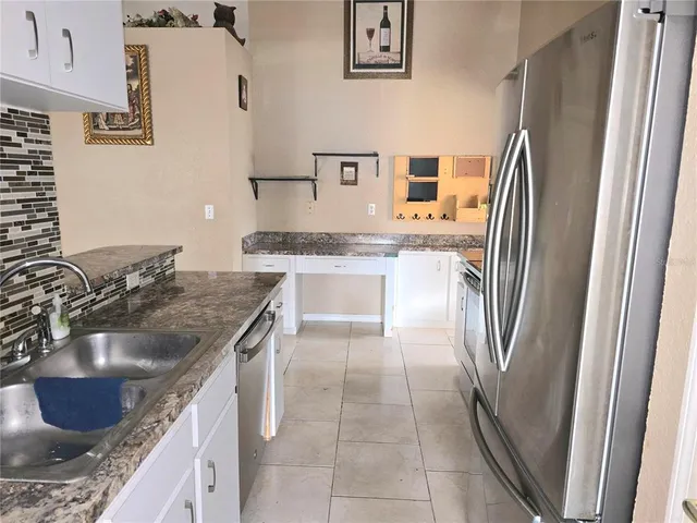 a kitchen with a sink refrigerator and microwave