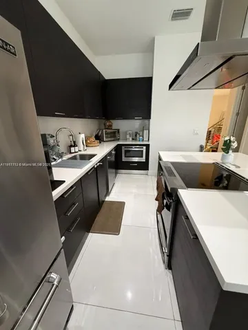 a white kitchen with a stove a sink and a refrigerator