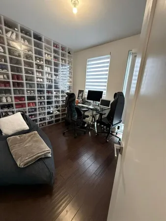 a view of a livingroom with workspace and a window