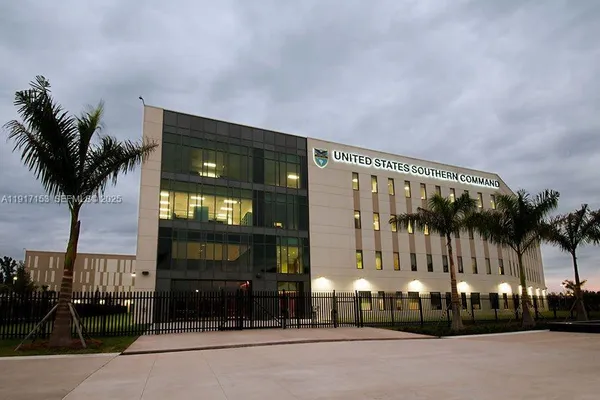 a view of swimming pool with palm trees