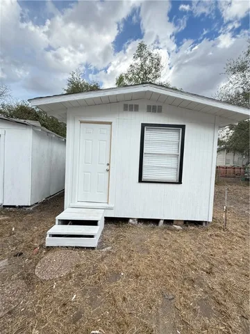 a white house with tree in the background