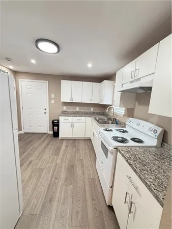 a kitchen with a sink stove and white cabinets