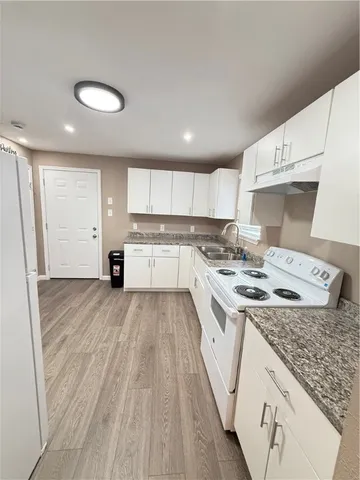 a kitchen with a sink stove and white cabinets