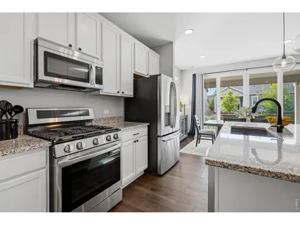 a kitchen with stainless steel appliances granite countertop a stove a sink and a refrigerator