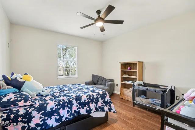 a bedroom with a bed and wooden floor