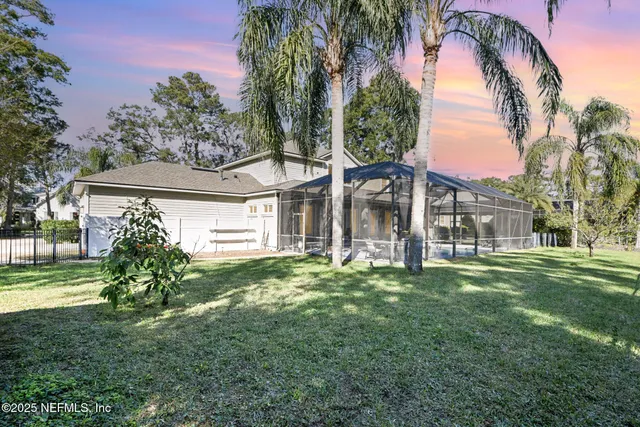 a view of a house with a big yard and a large trees