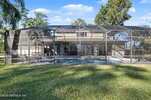 a view of a house with a yard patio and swimming pool