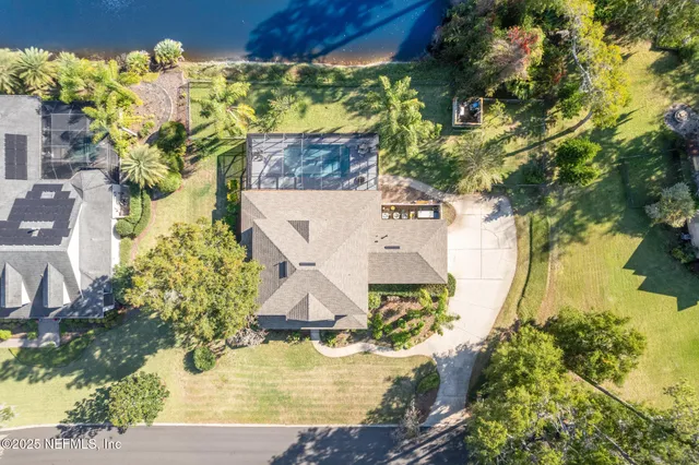 an aerial view of a house with a yard swimming pool and outdoor seating