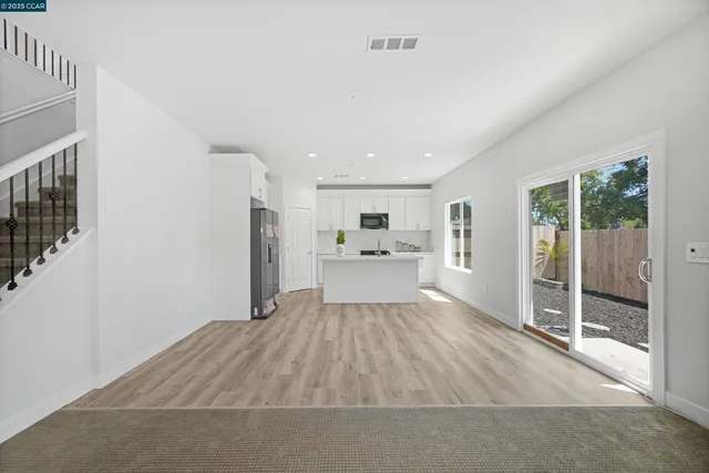 a kitchen with stainless steel appliances granite countertop a sink stove refrigerator and cabinets