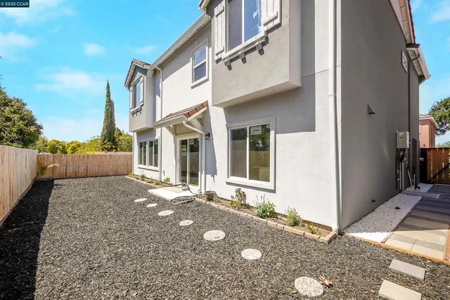 an aerial view of a city with lots of residential buildings ocean and mountain view in back