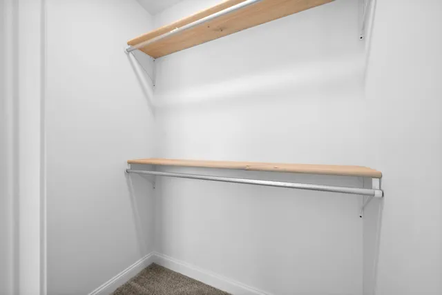 an empty room with windows and ceiling fan