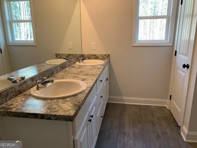 a bathroom with a granite countertop sink and a mirror