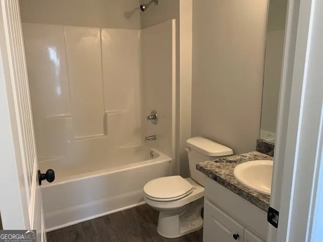 a bathroom with a granite countertop toilet a sink and bathtub