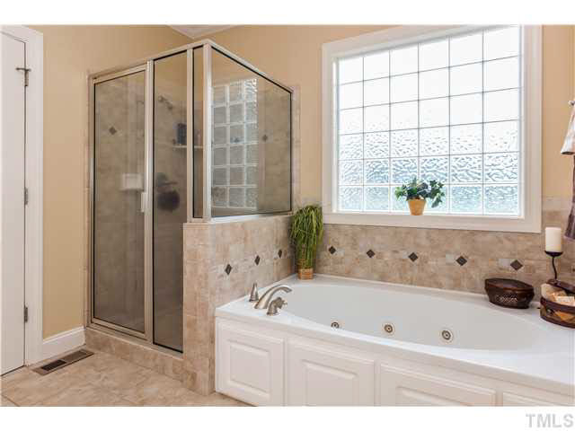 5820 Turner Store Lane Raleigh, NC 27603 - Photo 14 of 25 Master bath also features separate shower with tile surround finish, and garden soak Jacuzzi tub with brushed nickel hardware. Custom tilework is found everywhere here - walls, floors and even the half wall separating tub/shower.