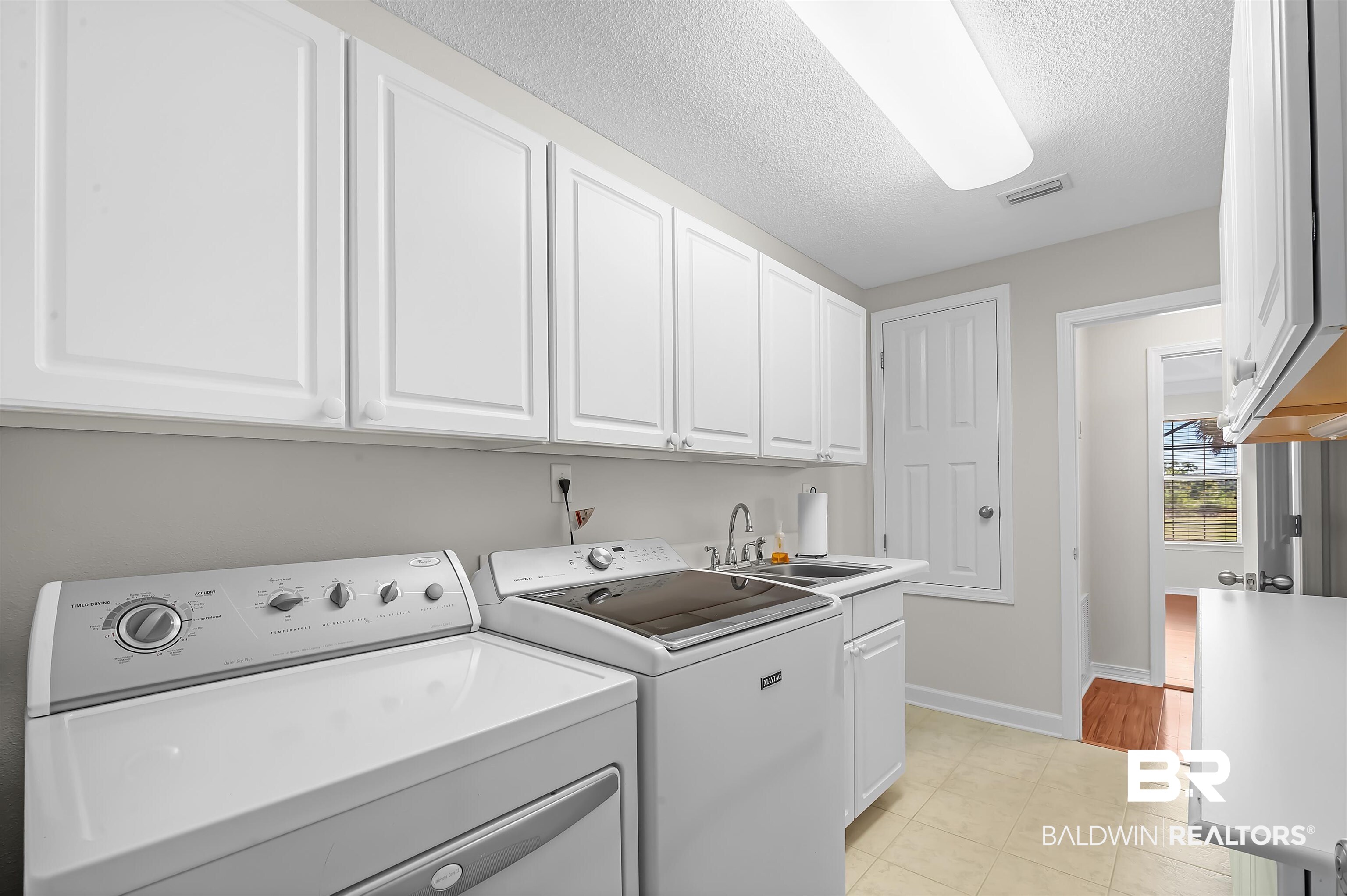421 Collinwood Loop Foley, AL 36535 - Photo 34 of 62 Laundry area with cabinets, light tile patterned floors, washer and dryer, a textured ceiling, and sink