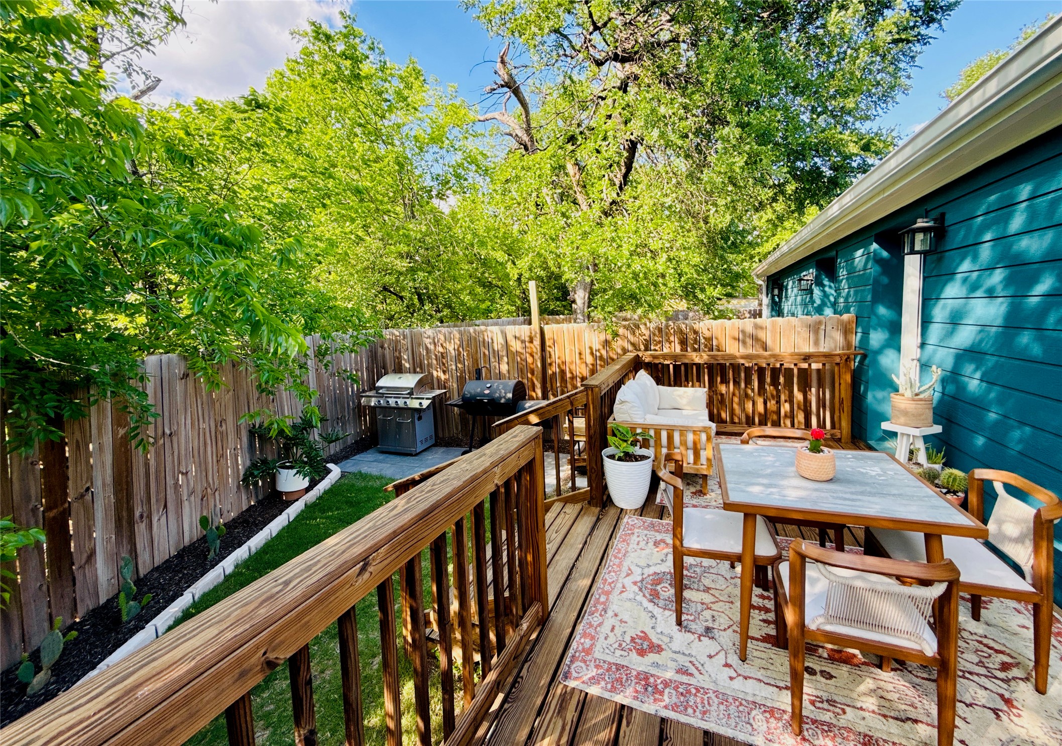 1616 Webberville Road, Unit A Austin, TX 78721 - Photo 7 of 35 The property features a wooden deck with a railing, a wooden fence, and a green lawn area