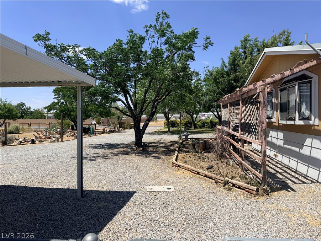 1391 West Dyer Road Pahrump, NV 89048 - Photo 28 of 50 A welcoming front yard features gravel landscaping and mature shade trees.