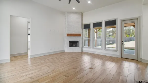 a view of a livingroom with wooden floor and a fireplace
