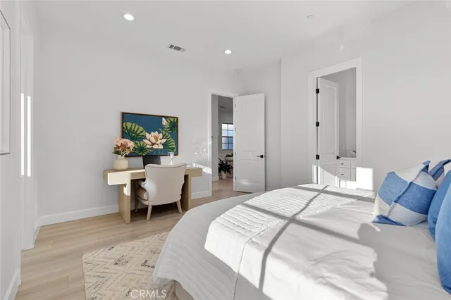 a bedroom with a large bed and a chandelier