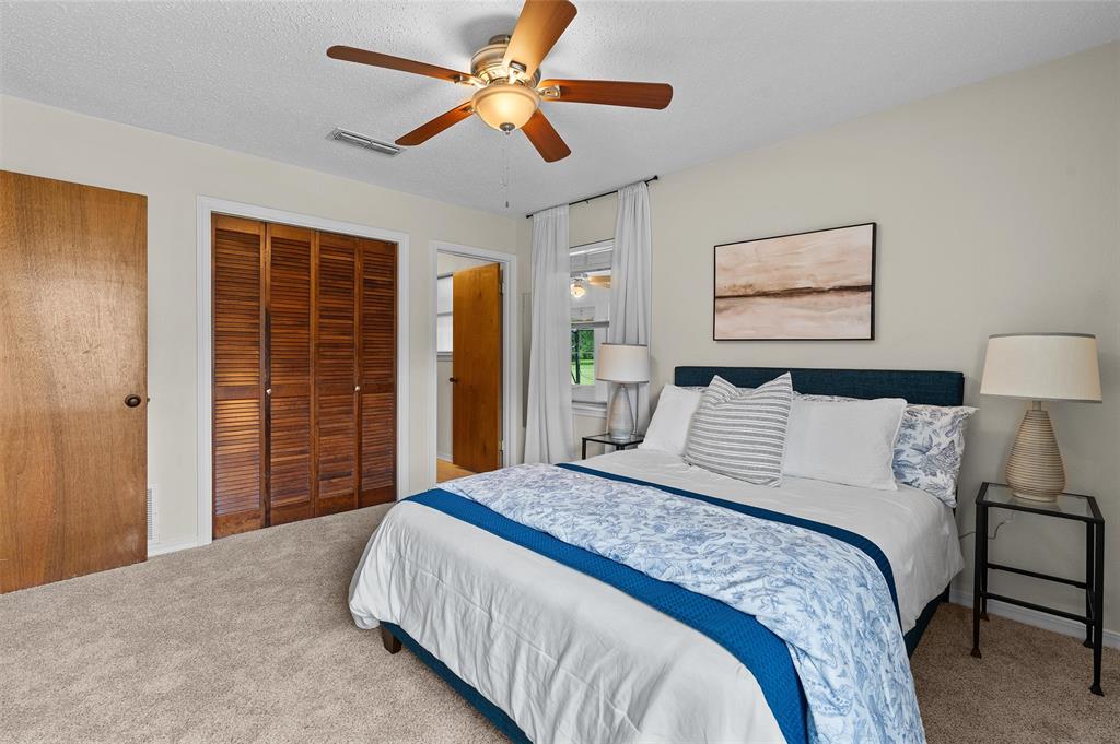 927 Stonewall-Preston Road Stonewall, LA 71078 - Photo 18 of 28 a bedroom with a large bed and a chandelier