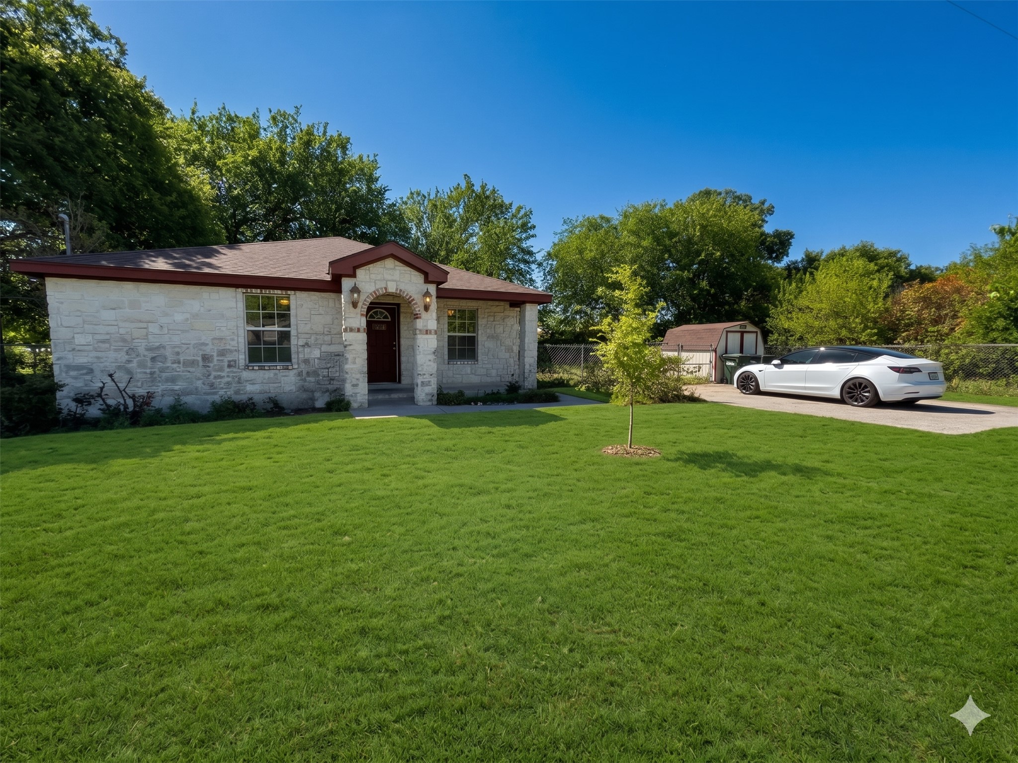 2004 Maple Street Georgetown, TX 78626 - Photo 1 of 31 Stone veneer exterior with a prominent arched entry, dark wood-finish front door, and a brown shingle roof