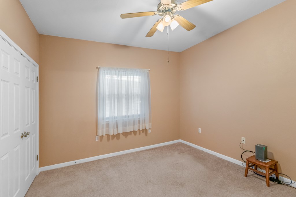 225 Los Cedros Loop Kerrville, TX 78028 - Photo 16 of 27 an empty room with windows and chandelier fan