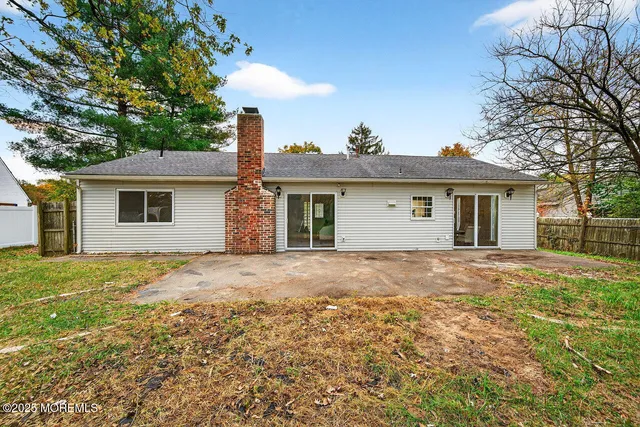 a backyard of a house with large trees and brick walls