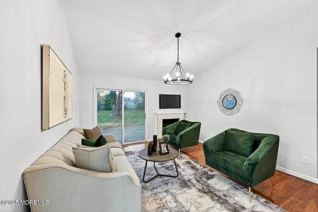 a living room with furniture a chandelier and a window