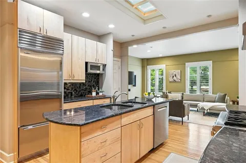 a kitchen with stainless steel appliances granite countertop a sink stove and refrigerator