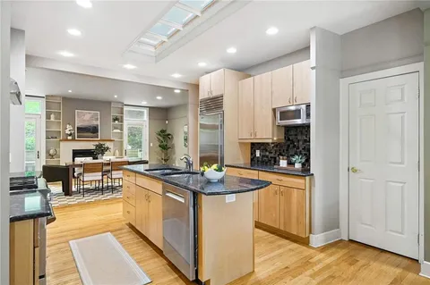 a kitchen with stainless steel appliances granite countertop a sink refrigerator and cabinets