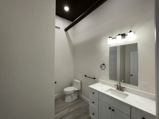 a bathroom with a sink and mirror with toilet