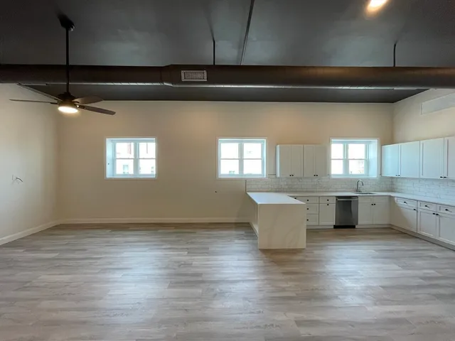 a view of kitchen with granite countertop white cabinets and white appliances
