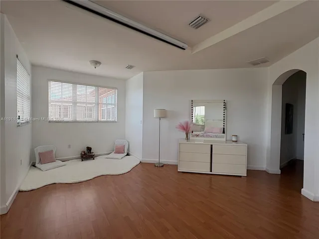 a spacious bedroom with a bed and a large window