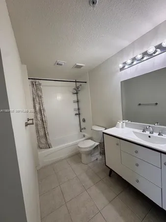 a bathroom with a double vanity sink toilet mirror and shower