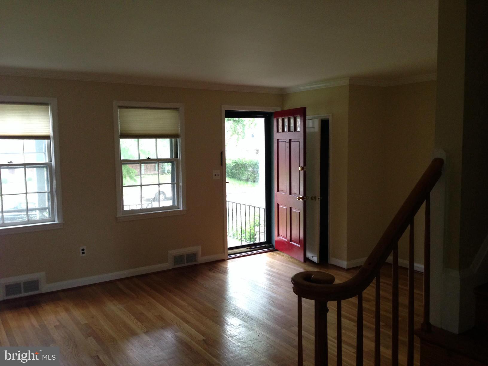 1220 Cedarcroft Road Baltimore, MD 21239 - Photo 1 of 22 a view of a livingroom with wooden floor and stairs