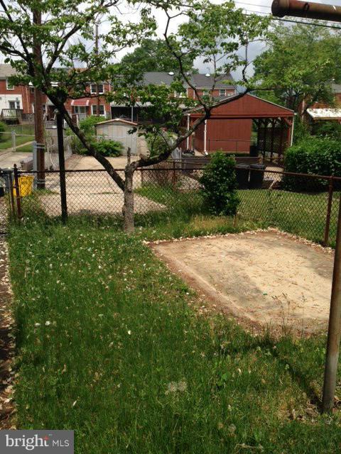 1220 Cedarcroft Road Baltimore, MD 21239 - Photo 11 of 22 a view of a street with a bench and trees in the background