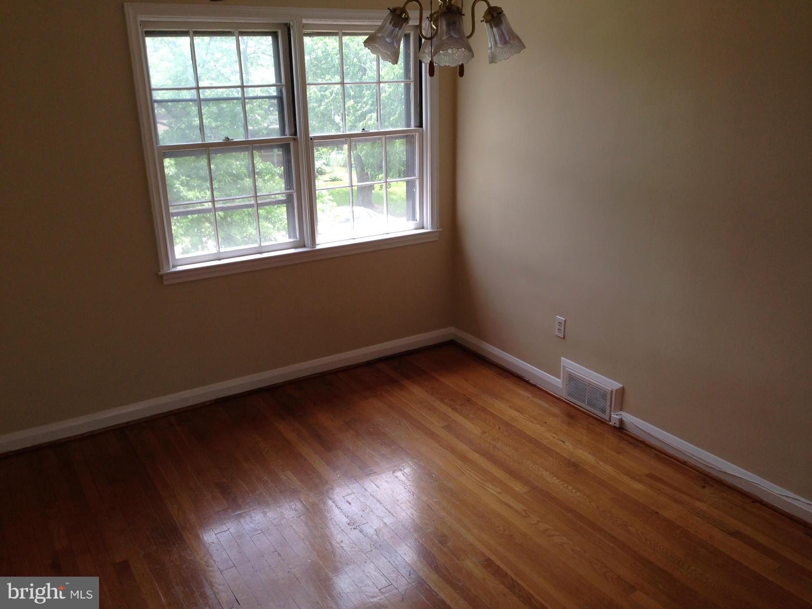 1220 Cedarcroft Road Baltimore, MD 21239 - Photo 14 of 22 an empty room with wooden floor and windows