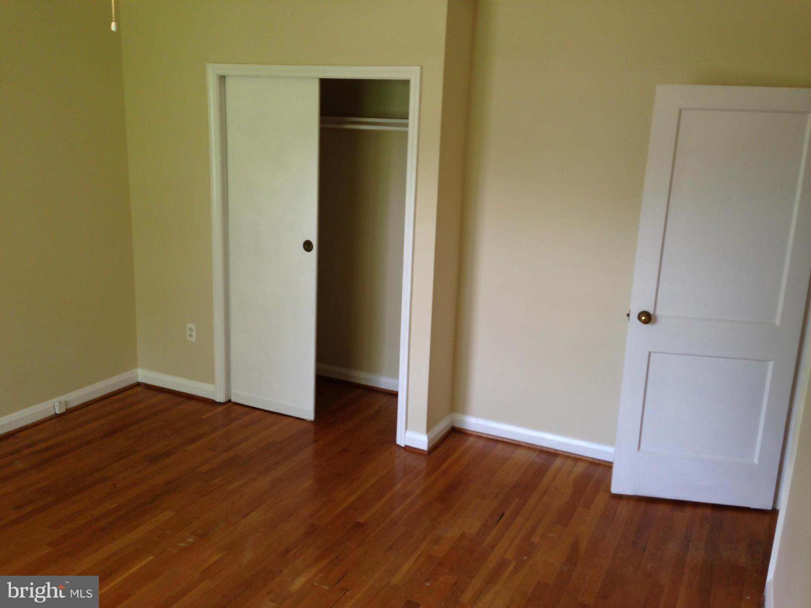 1220 Cedarcroft Road Baltimore, MD 21239 - Photo 16 of 22 a view of an empty room with wooden floor and a window