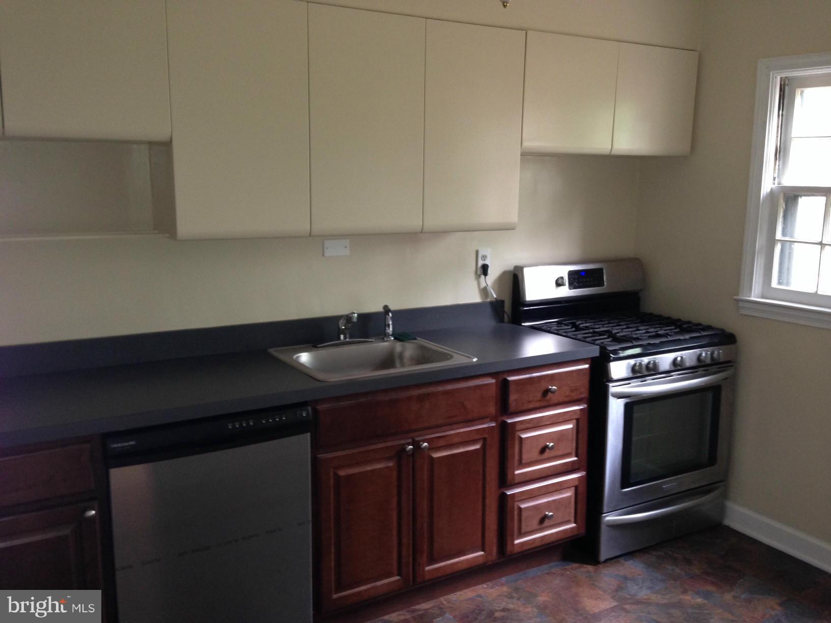 1220 Cedarcroft Road Baltimore, MD 21239 - Photo 7 of 22 a kitchen with granite countertop a sink stove and cabinets