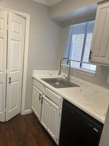 a kitchen with a sink cabinets and a window
