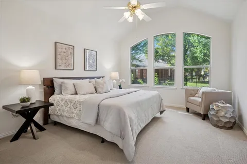 a spacious bedroom with a bed and a chandelier
