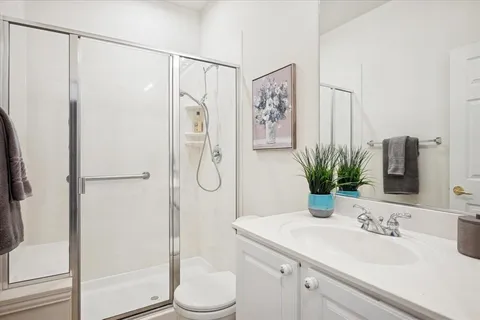 a bathroom with a granite countertop sink toilet and shower
