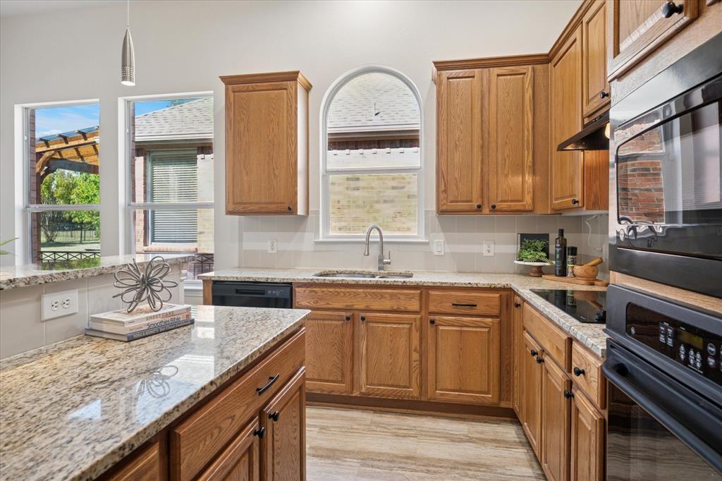 351 Rio Bravo Drive Fairview, TX 75069 - Photo 9 of 20 a kitchen with granite countertop a sink stove and cabinets