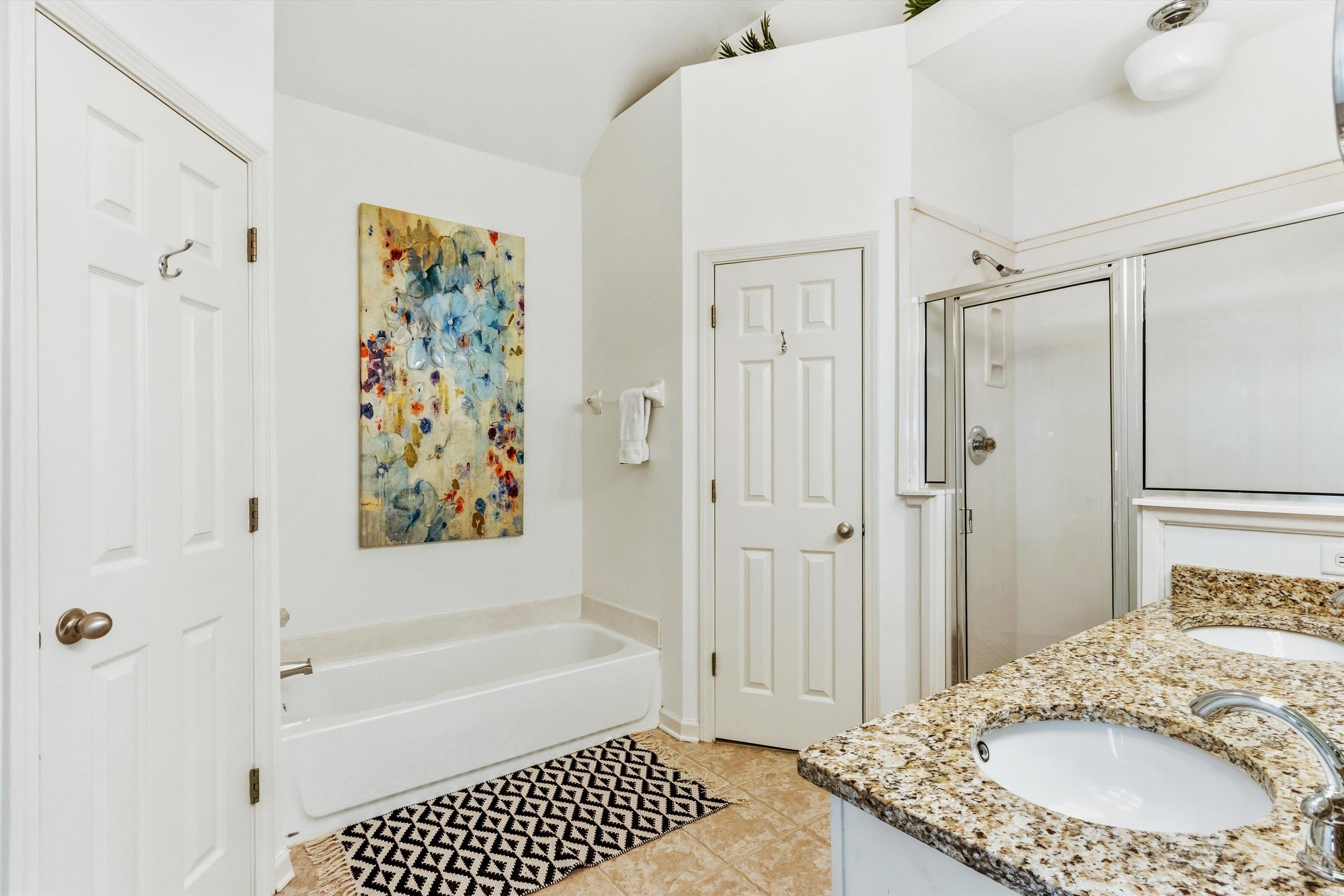 1182 Isle View Drive Memphis, TN 38103 - Photo 15 of 27 a bathroom with a granite countertop sink a mirror a bathtub and shower
