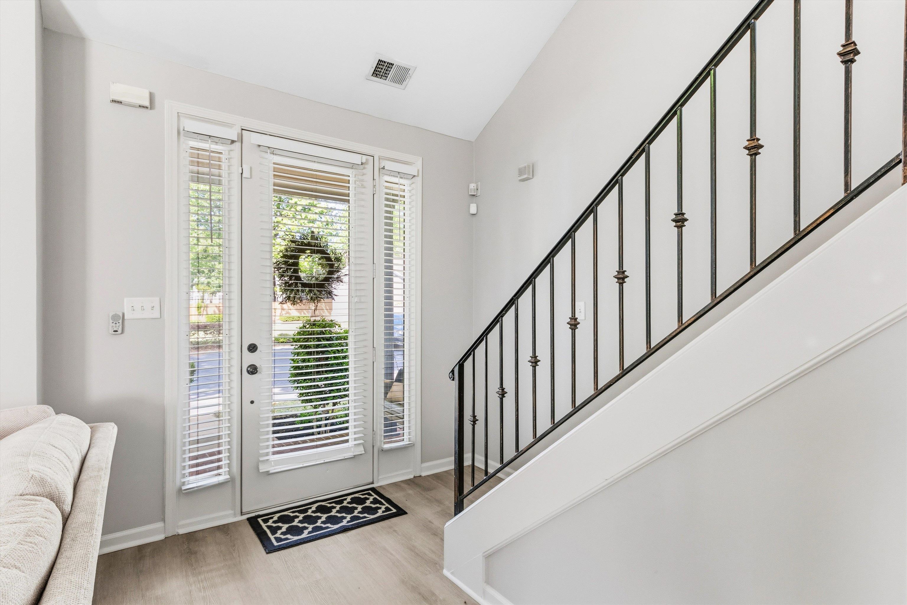 1182 Isle View Drive Memphis, TN 38103 - Photo 6 of 27 a view of a hallway with wooden floor and stairs