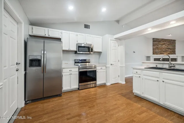 a kitchen with stainless steel appliances a refrigerator sink and stove